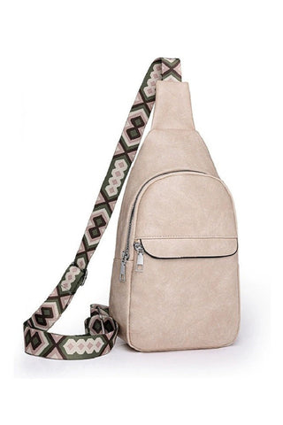 Beige sling bag with patterned strap on a white background