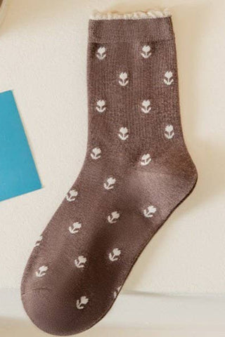 Brown sock with white floral pattern on a light background