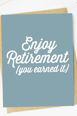 Greeting card with 'Enjoy Retirement (you earned it)' text on a light blue background with a brown envelope.