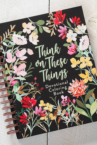 Coloring book titled 'Think on These Things' with flowers and text, placed on a wooden surface with coloring supplies.