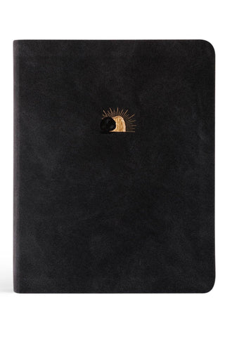 Black Bible with a sun design on a white background
